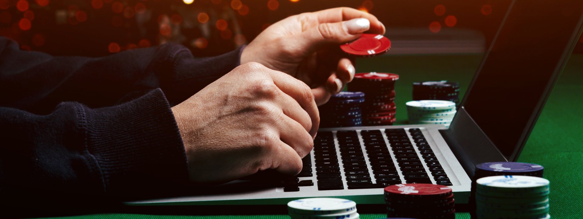 Skrill online gambling for business, man hands holding poker chips on a Mac book